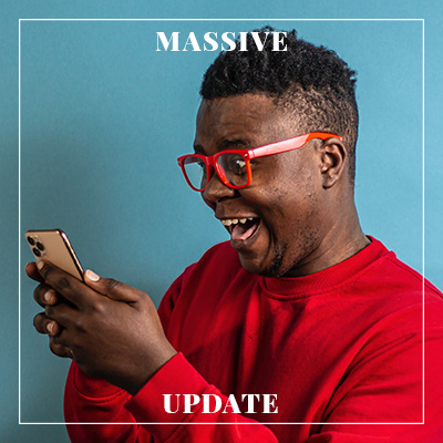Photo of a man happily looking at his smart phone.