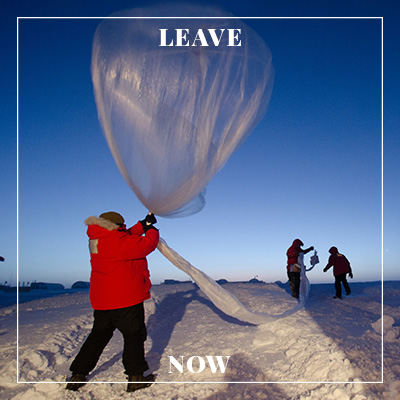 A man releasing a large silver balloon.
