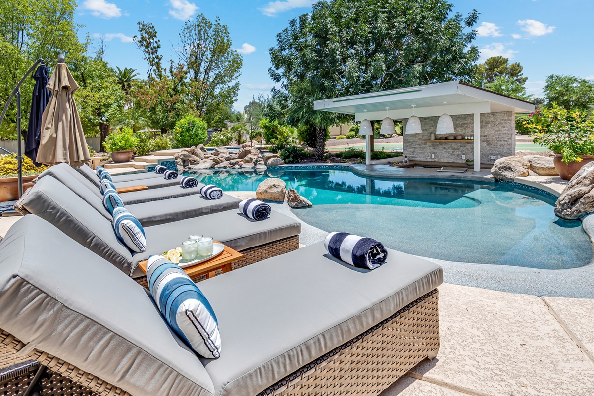 Photo of lounge chairs and a pool.