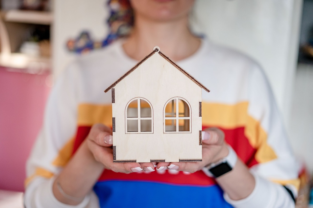 A woman holding a model home.